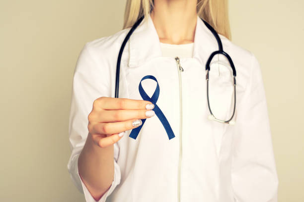 Doctor hands holding blue ribbon, diabetes and Colorectal Cancer Awareness Doctor hands holding blue ribbon, diabetes and Colorectal Cancer Awareness - Image women movember mustache facial hair stock pictures, royalty-free photos & images