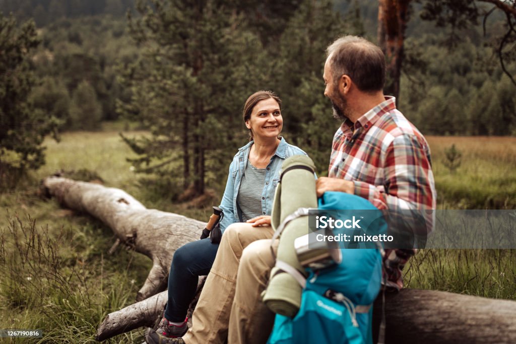 Wanderpaar entspannt auf umgestürztem Baum - Lizenzfrei 45-49 Jahre Stock-Foto