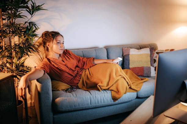 istock Young women watching tv at home 1267191028