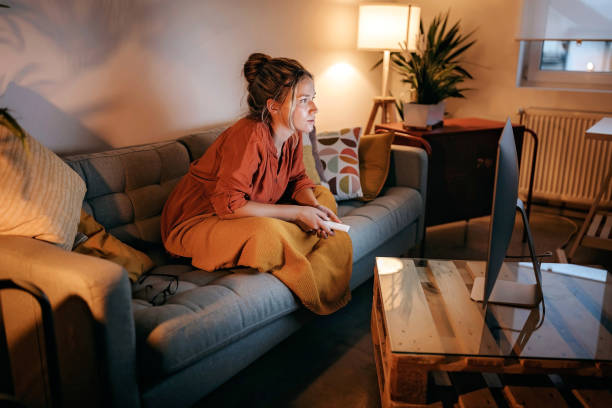 jeunes femmes regardant la télévision à la maison - movies at home photos et images de collection