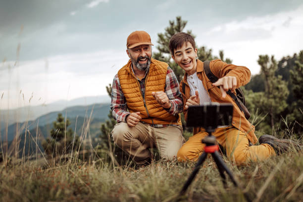 istock Father with son hiking and vlogging using mobile phone 1267191207