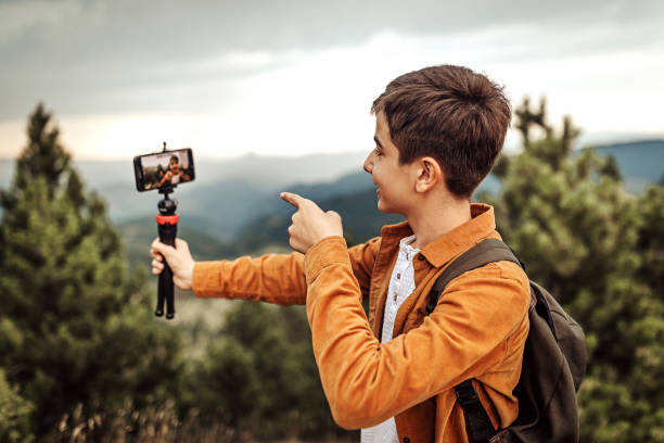 istock Boy hiking and vlogging using mobile phone 1267191831