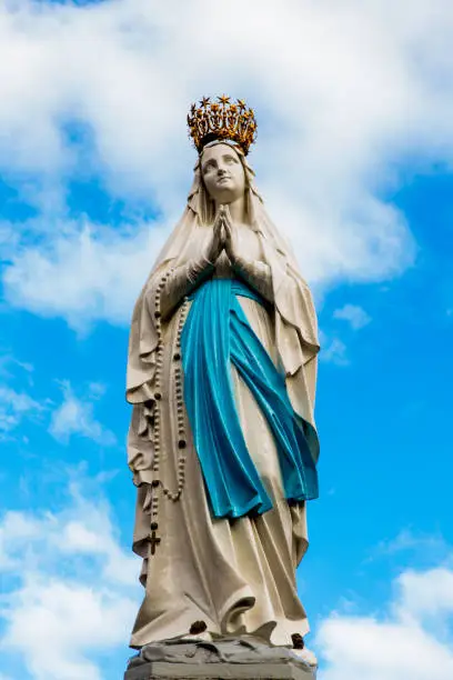Statue of Our Lady in front of a cloudy sky