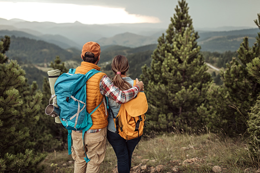 Rear view of couple admiring scenic view on hiking tour, hiking after Covid-19 quarantine.