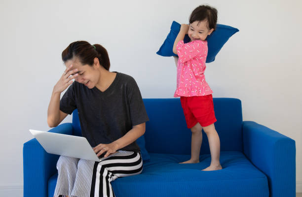 istock Mothers working at home often have problems with disturbing from their children. Although she is a lovely daughter, but she is naughty, curious and always want to play. It causes the mother to have a headache and trouble. 1267193175