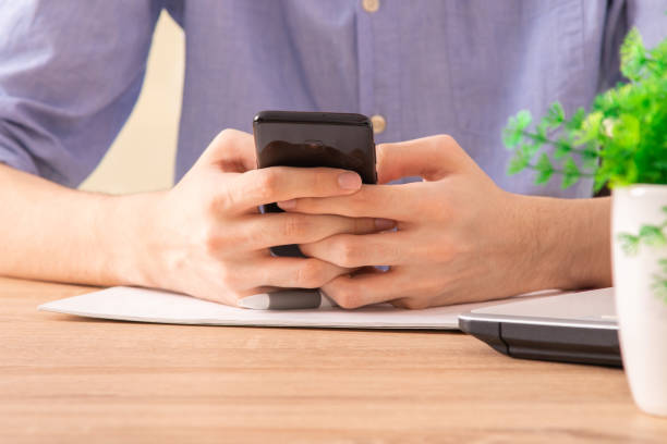 istock close-up of hands with mobile phone at desk 1267196648
