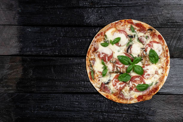 istock Pizza on dark wooden background 1267200211