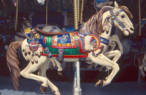 Carousel Horse on a Merry Go Round ride at the State Fair with carved Indian Chief head and war shield with feathers.