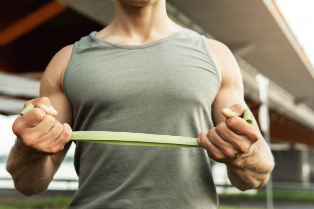 istock Man during  workout with a resistance rubber bands outdoors. 1267202076