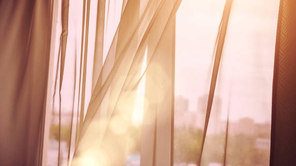 istock wind blows off room curtain against blurry cityscape closeup 1267203912