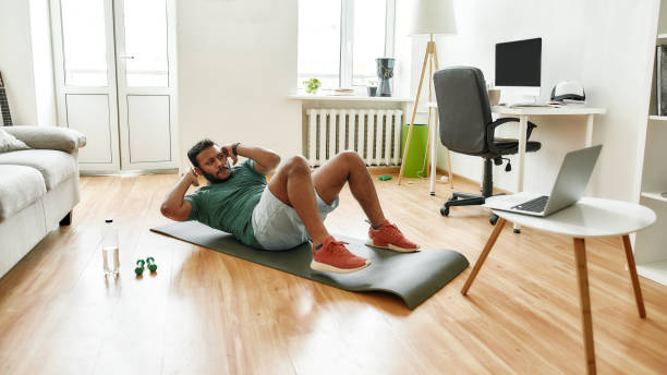 istock Your personal trainer. Male fitness instructor showing exercises while streaming, broadcasting video lesson on training at home using laptop. Sport, online gym concept 1267204102