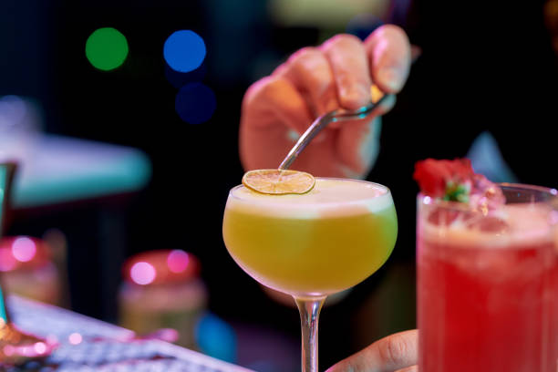 istock Trendy Taste. Close up of male bartender adding dried lime to cocktail while making alcoholic drink at the bar counter in the night club 1267204285