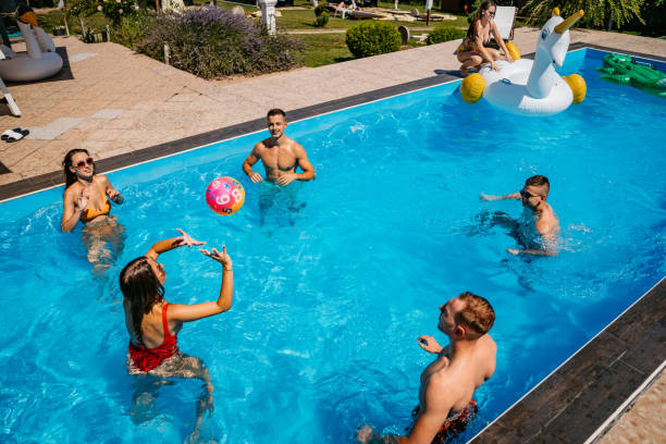 amigos jugando voleibol en la piscina - swimwear bikini swimming pool red fotografías e imágenes de stock