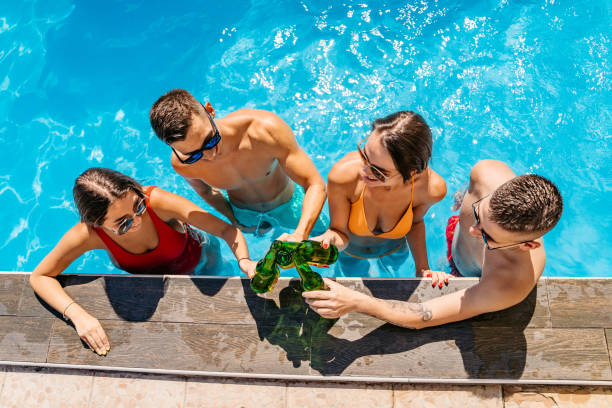 istock Friends drinking beer in swimming pool 1267205595