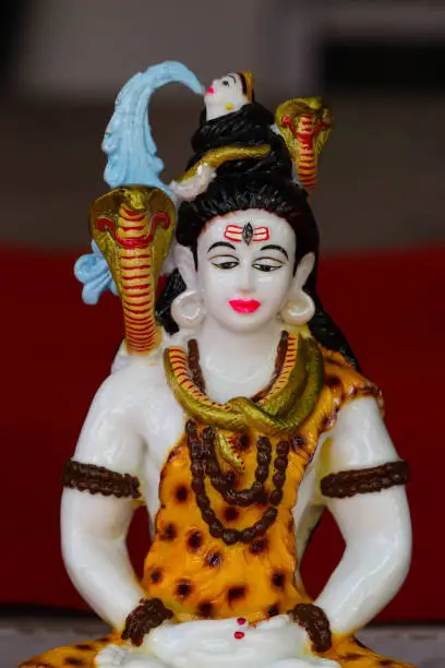 Photo of Colorful Beautiful Painted Handcrafted Statue Of Indian Hindu Lord Idol Shankar Shiva Bhagwan Om Namah Shivay God Of Destruction Har Har Mahadev With Damru Trishul And Snake Made Of Earthenware Mud Clay Stone Or Rock For Worship Pooja Puja In Maha Shivara