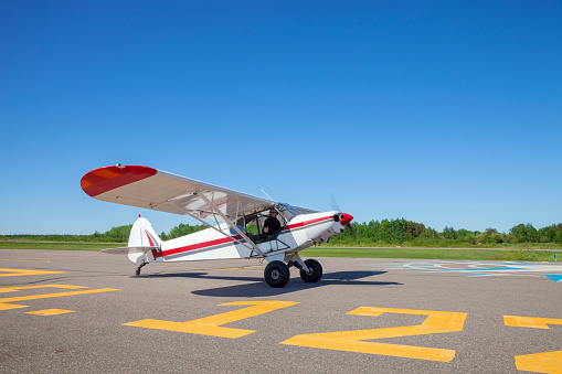 Pilot in small single engine plane taxis toward runway for take off