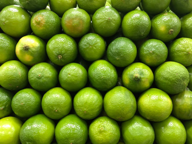 istock Many green lemons geometrically stacked. 1267212210