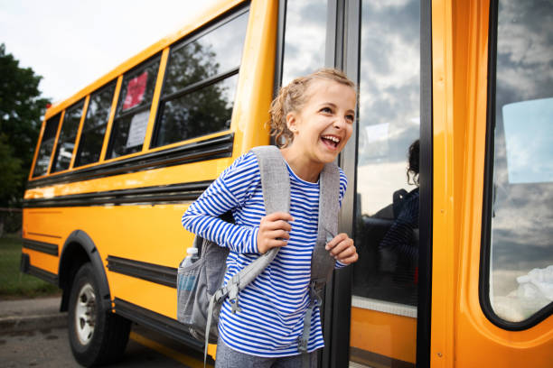 istock Girl in Front of a School Bus 1267213036