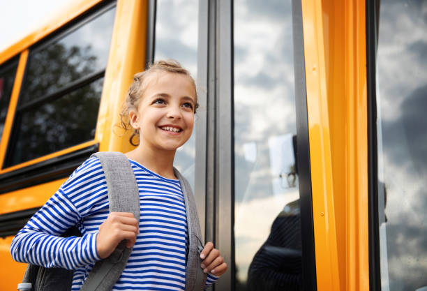 istock Girl in Front of a School Bus 1267213037