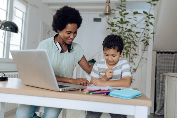 istock African-American woman working and assisting her son while doing homework 1267214009