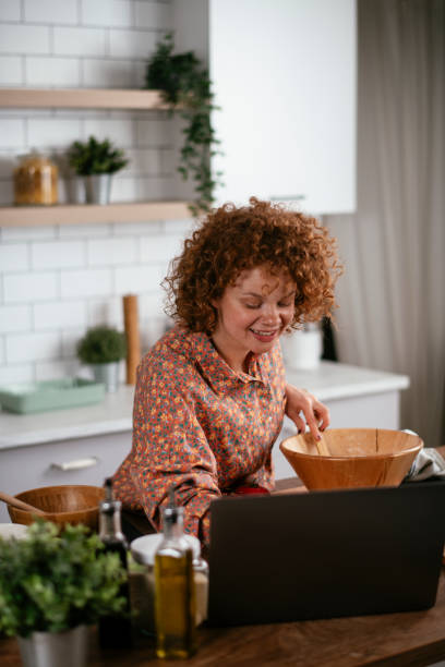 istock Young woman cooking while having video call. 1267216357