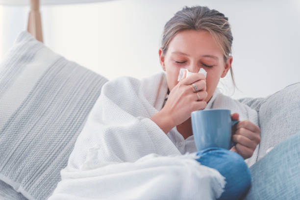 istock Woman sitting on the sofa with a cold, flu or allergy. 1267218045