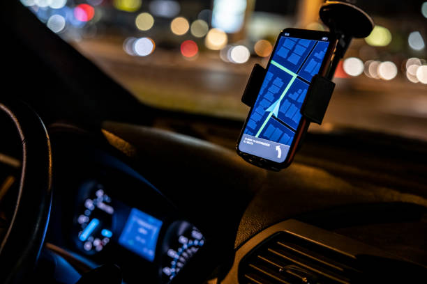 Car Driver with GPS Phone based GPS in a car at night. crowdsourced taxi stock pictures, royalty-free photos & images