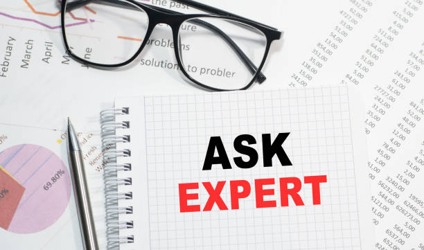 istock Business concept. Notebook with text ASK THE EXPERT sheet of white paper for notes, calculator, glasses, pencil, pen, in the white background 1267226316