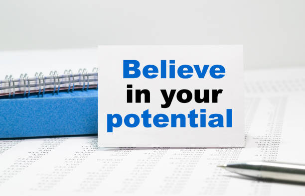 istock BELIEVE IN YOUR POTENTIAL text on white card, amid financial statements 1267226319