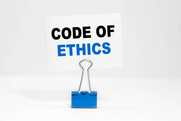 istock Code of Ethics inscription on a white business card on a white endless background in a blue clip. 1267226324