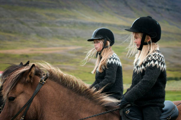 Tourist ride horse at Kirkjufell mountain landscape and waterfall in Iceland summer. Kirjufell is the beautiful landmark and the most photographed destination which attracts people to visit Iceland.
