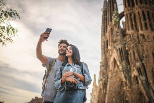 vacationing young couple taking selfie at sagrada familia - tourists couple barcelona imagens e fotografias de stock