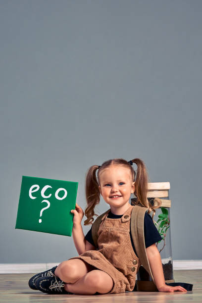 istock Little girl have terrarium jar with plant isolated on grey 1267228607