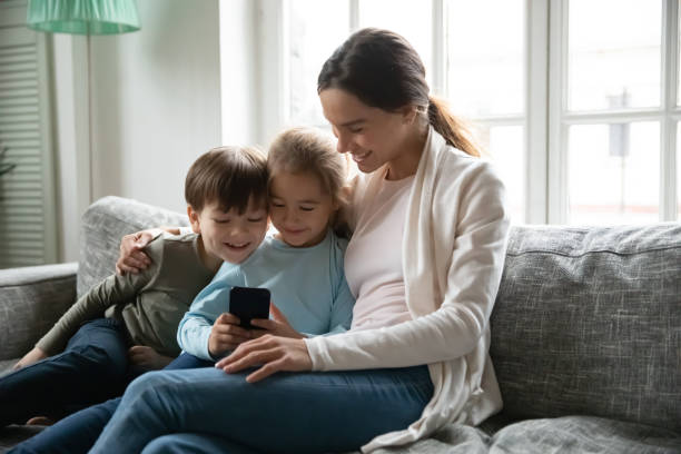 istock Little children watching funny video on smartphone with mum. 1267228678