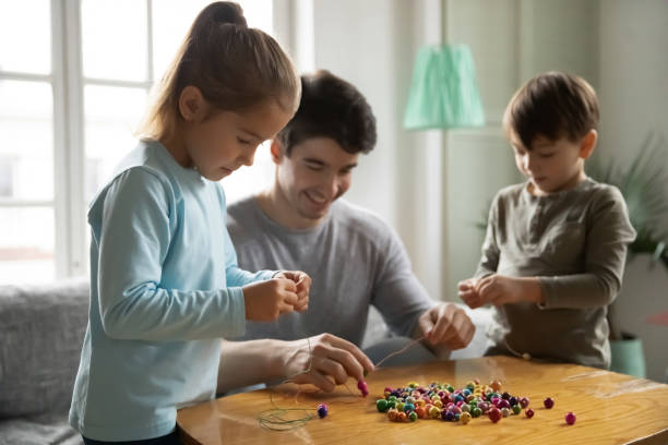 istock Smiling young daddy involved in handmade activity with small kids. 1267228685