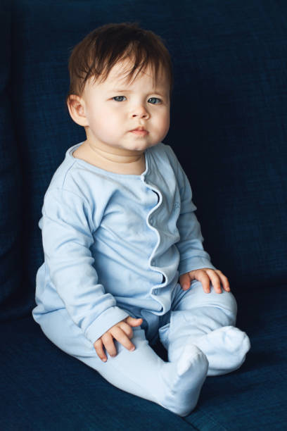 istock Cute little boy is playing on blue sofa 1267229119