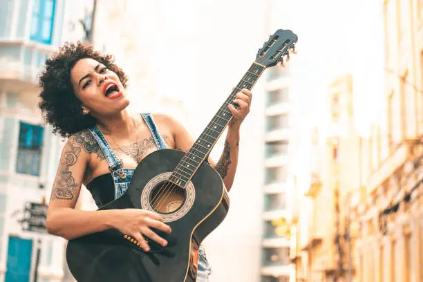 Photo of Woman playing guitar outdoors