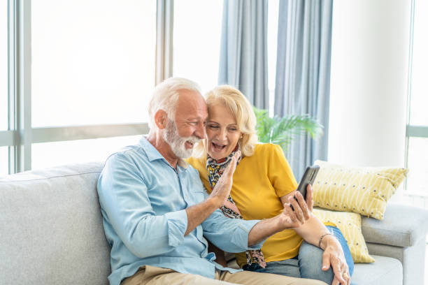 istock Happy mature couple taking a selfie on sofa. 1267232461