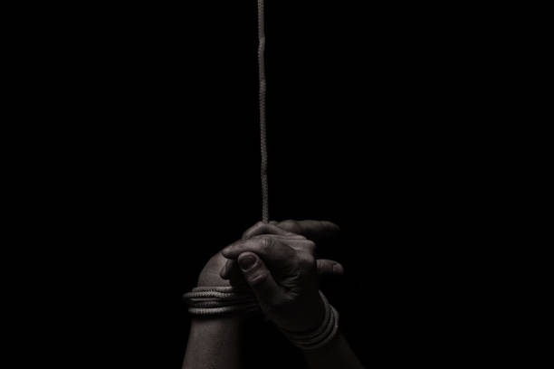 istock woman hands bound prisoner in room 1267245205