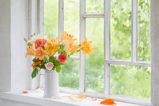 istock summer flowers in vase on background window with drops water 1267247293
