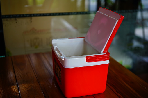 red box storage plastic container or cooling box on table.