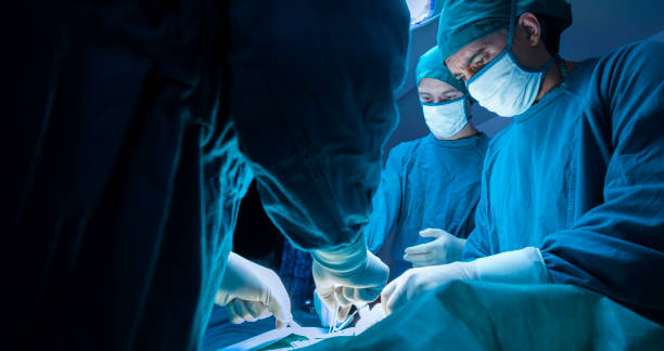 konzentriertes professionelles chirurgisches ärzteteam, das einen patienten im operationssaal des krankenhauses operiert. gesundheits- und medizinkonzept." n - operation fotos stock-fotos und bilder
