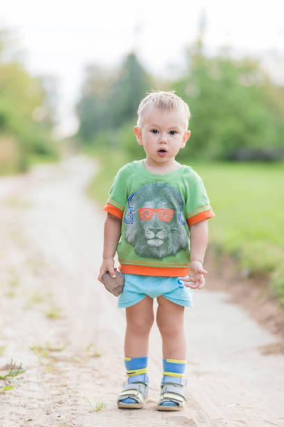 istock A surprised boy with an open mouth and a stone in his hands 1267251923