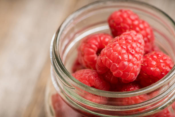 istock Ripe juicy raspberries in jar. Selective focus. 1267254979