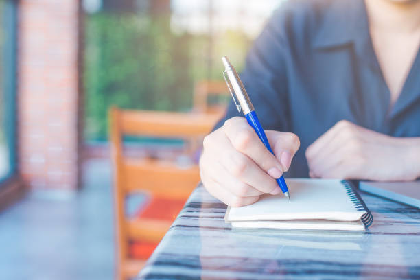 istock Woman is writing on a notebook with a pen in the office. 1267259040