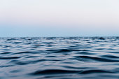 Water surface. Sky background. Evening sky clouds over the sea. View of a Crystal clear sea water texture. Landscape. Small waves. Water reflection