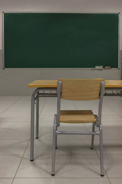 istock Back to school, empty class, green blackboard, table and chair, classroom with covid 1267259328