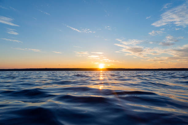 istock Water surface. View of a Sunset sky background. Dramatic gold sunset sky with evening sky clouds over the sea. View of a Crystal clear sea water texture. Landscape. Small waves. Water reflection 1267259384