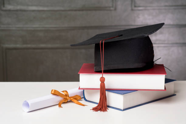 istock Graduation cap with books on white desk , Education background 1267263520