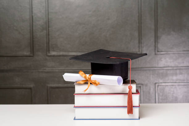 istock Graduation cap with books on white desk , Education background 1267263538